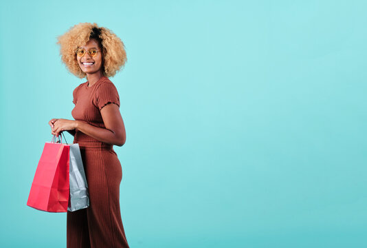 Smiling woman holding colorful shopping bags. Black Friday sales season concept.