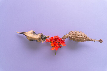 Modern arrangement of two brown dinosaurs and red flower