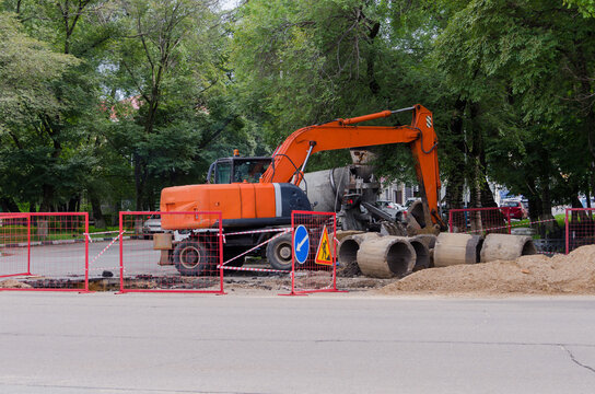 Excavator. Heavy machinery during road repairs. Replacement of sewer pipes