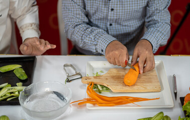 Chef carves patterns on cabbage and other vegetables and fruits for a beautiful table decoration