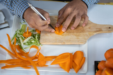 Chef carves patterns on cabbage and other vegetables and fruits for a beautiful table decoration