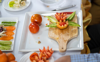 Chef carves patterns on cabbage and other vegetables and fruits for a beautiful table decoration