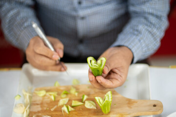 Obraz na płótnie Canvas Chef carves patterns on cabbage and other vegetables and fruits for a beautiful table decoration