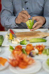 Chef carves patterns on cabbage and other vegetables and fruits for a beautiful table decoration