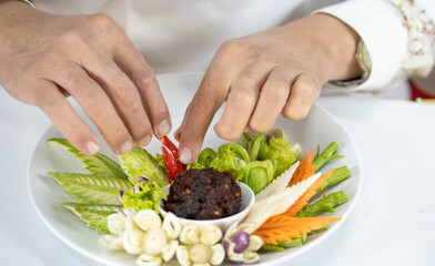 Chef carves patterns on cabbage and other vegetables and fruits for a beautiful table decoration