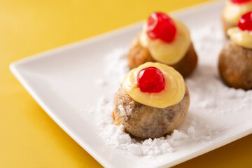 Traditional Italian Zeppole pastry on yellow background