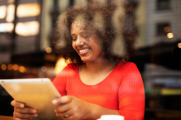 Businesswoman using tablet in cafe. Beautiful woman sitting in cafe, reading the news online.