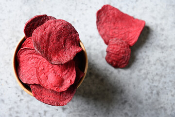 Vegetable beetroot chips on a gray background. Vegan snack. Top view. Close up. Copy space.