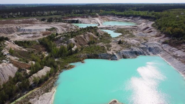 Small turquoise quarry lakes in abandoned kaolin pit, aerial view