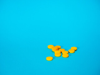 Yellow pills on blue background with copy space for text. Healthy and medicine. Pain management. Drug abuse in teenage concept