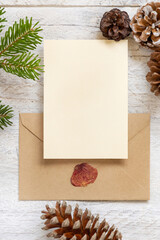 Fototapeta na wymiar Christmas Composition with a card over sealed envelope flat lay. Holiday mockup