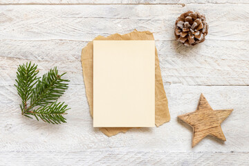 Christmas Composition with a card mockup near fir branch,  wooden star and pine cone flat lay