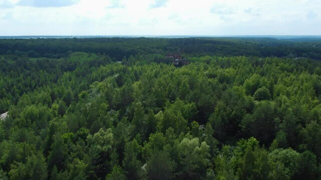Old abandoned bucket wheel excavator among the trees, aerial view