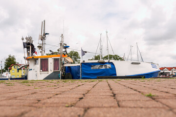 A beautiful white and blue fishing boat moored in the port of Darłowo on the Baltic Sea