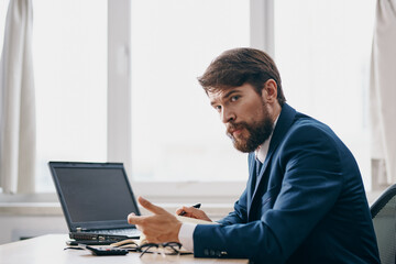 bearded man sitting at a desk in front of a laptop stress anger professional
