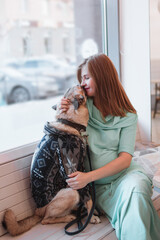 Beautiful young pregnant woman is hugging gently her dog. Pregnant lifestyle. Time to change.