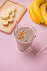 Fresh made Banana smoothie on pink background