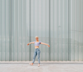 Young caucasian woman outdoor dancing celebrating success feeling free - advertising copyspace