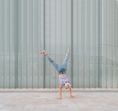 Young Caucasian Athletic Gymnast Woman Outdoors Soing Cartwheel Sportive And Dynamic