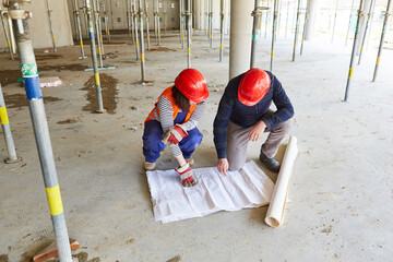 Architect and construction worker with blueprint in the shell