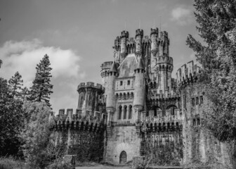 Fototapeta na wymiar Neo-gothic castle from the middle ages surrounded by nature in black and white