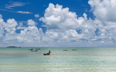 Sea and fishery boat with cloudy blue sky.
