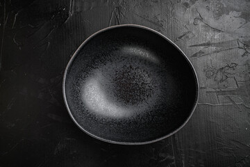 black pottery bowl, with copy space for text or food, with copy space for text or food, top view flat lay , on black dark stone table background