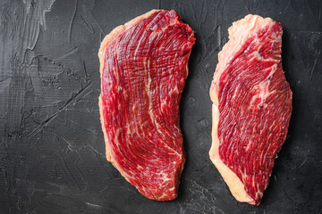 Set of picanha raw beef steaks on black textured background, top view space for text.