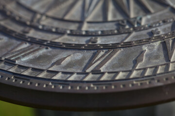 Closeup on number six on an industrial style wall clock with roman numerals under the sunlight