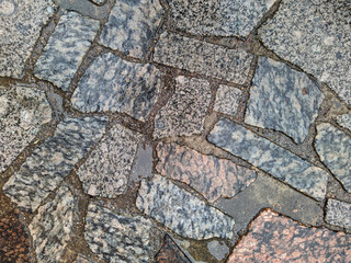 wet sidewalk made of abstract drawings of colored stones.