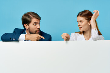 business man and woman with white mockup poster advertising sign blue background