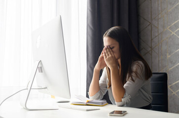 Tired female student feel bored and tired, an attractive brunette woman sits with eyes closed in...