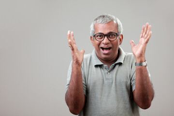 Mature man of Indian ethnicity with a cheering expression