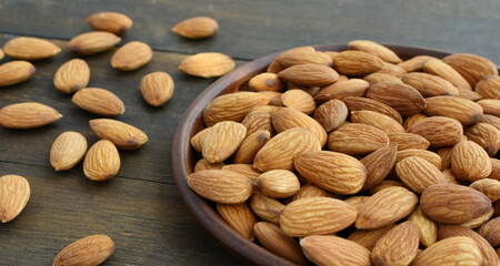Almonds in a bowl on a wooden table close-up