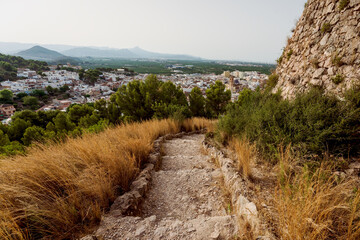 Fototapeta na wymiar Path to the castle 'Santa Anna' with aerial view on the Spanish old town Oliva, Spain