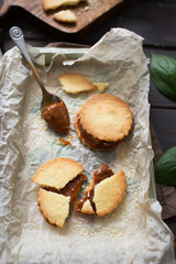 Shortbread cookies with salted caramel. Preparation of dessert. Cookies on a wooden table. Cooking sweets