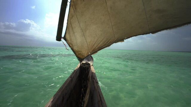 Sailing with a Dao, shot from a boat deck, to bright blue sea of Zanzibar