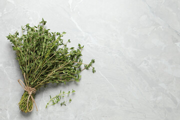 Bunch of aromatic thyme on light table, top view. Space for text