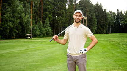 Young man with golf club looking at camera