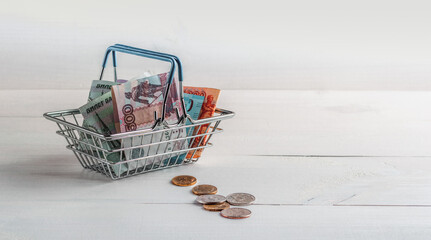 Russian paper and metal money in a shopping cart from a supermarket. Sales and purchases. Copy...