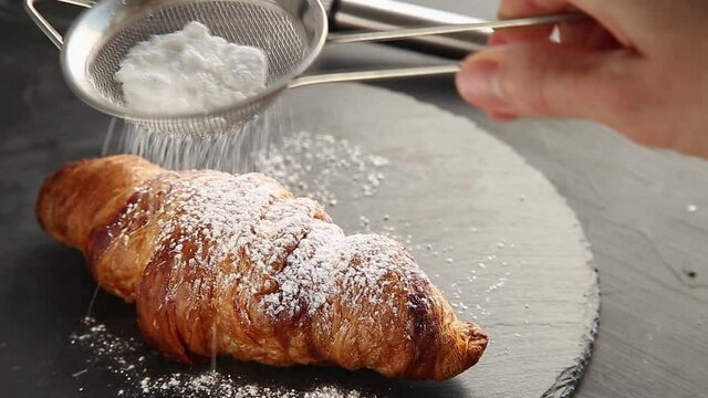 Delicious croissant on a black plate with a delicious croissant.