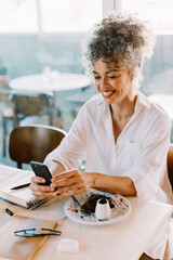 Cheerful businesswoman taking a video call in a cafe