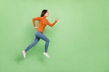 Fototapeta na wymiar Full length body size profile side view of pretty sportive confident cheerful girl jumping running isolated over bright green color background