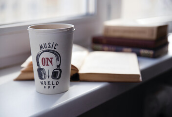 old books and coffee near window for morning relaxing time. sunshine and cosiness