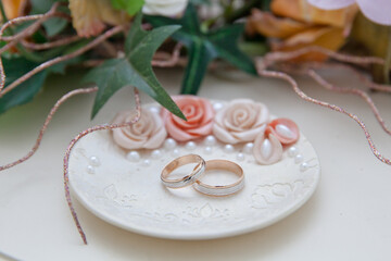 Wedding rings. Two gold rings on a saucer.