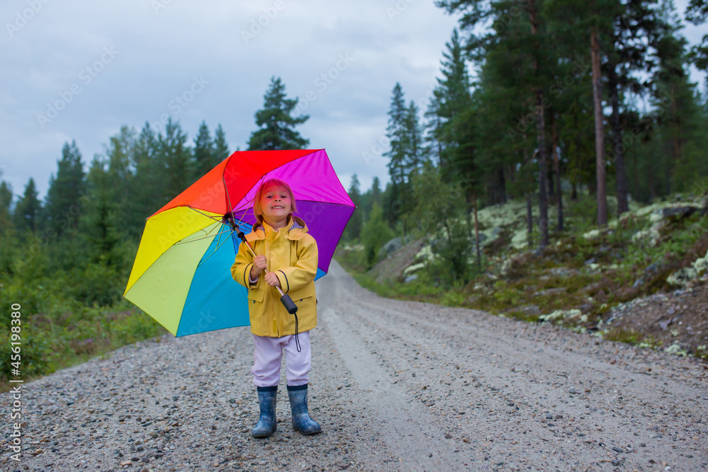 Canvas Prints Cute toddler child with colorful umbrella, playing in the forest on a rainy day