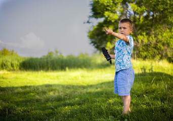 the boy holds binoculars in his hands and points his finger forward