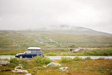 Family car with box on top, parked on a parking next to North arctic circle, where no trees and grass grow