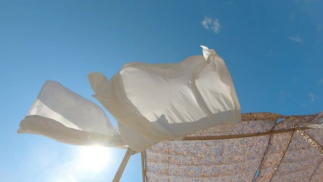 White fabric curtains fluttering in the wind. Summer vacation beach tent in luxury resort
