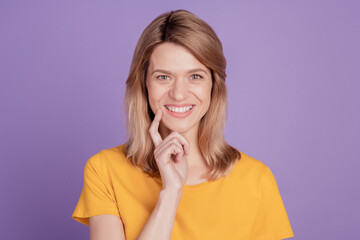 Photo of happy charming cute young woman attractive happy smile finger touch chin isolated on violet color background